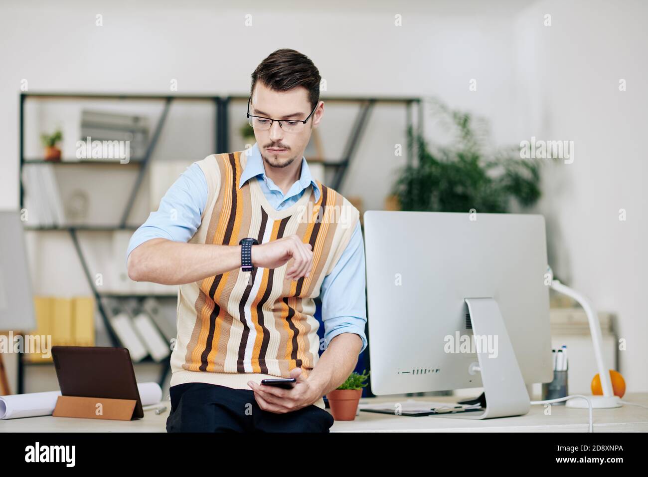 Entrepreneur checking smartwatch Stock Photo