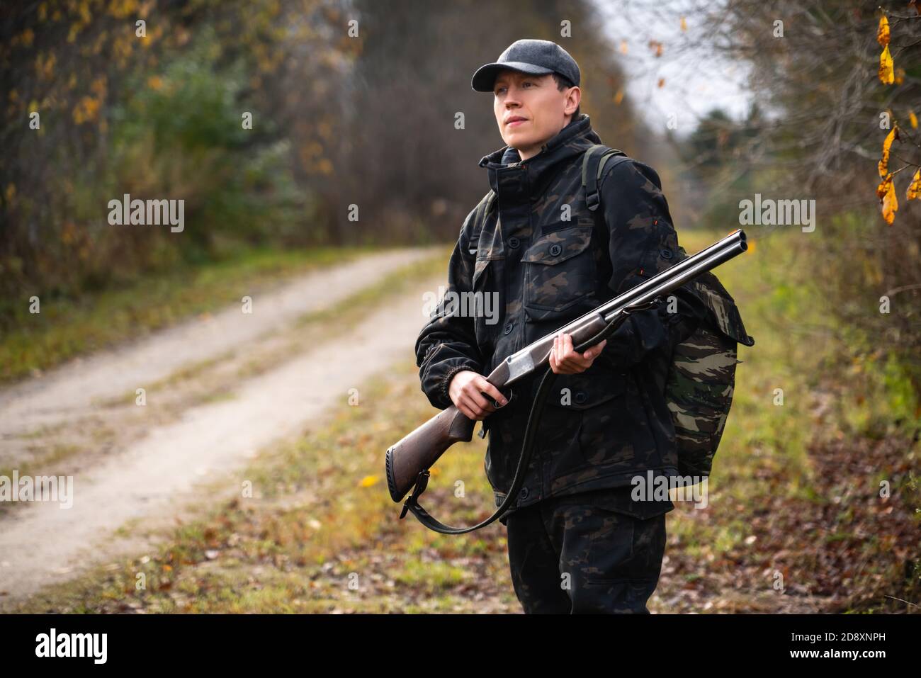 Hunter with a gun and a backpack in the a forest Stock Photo