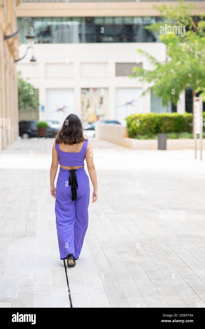 Rear view of woman walking away in the city Stock Photo