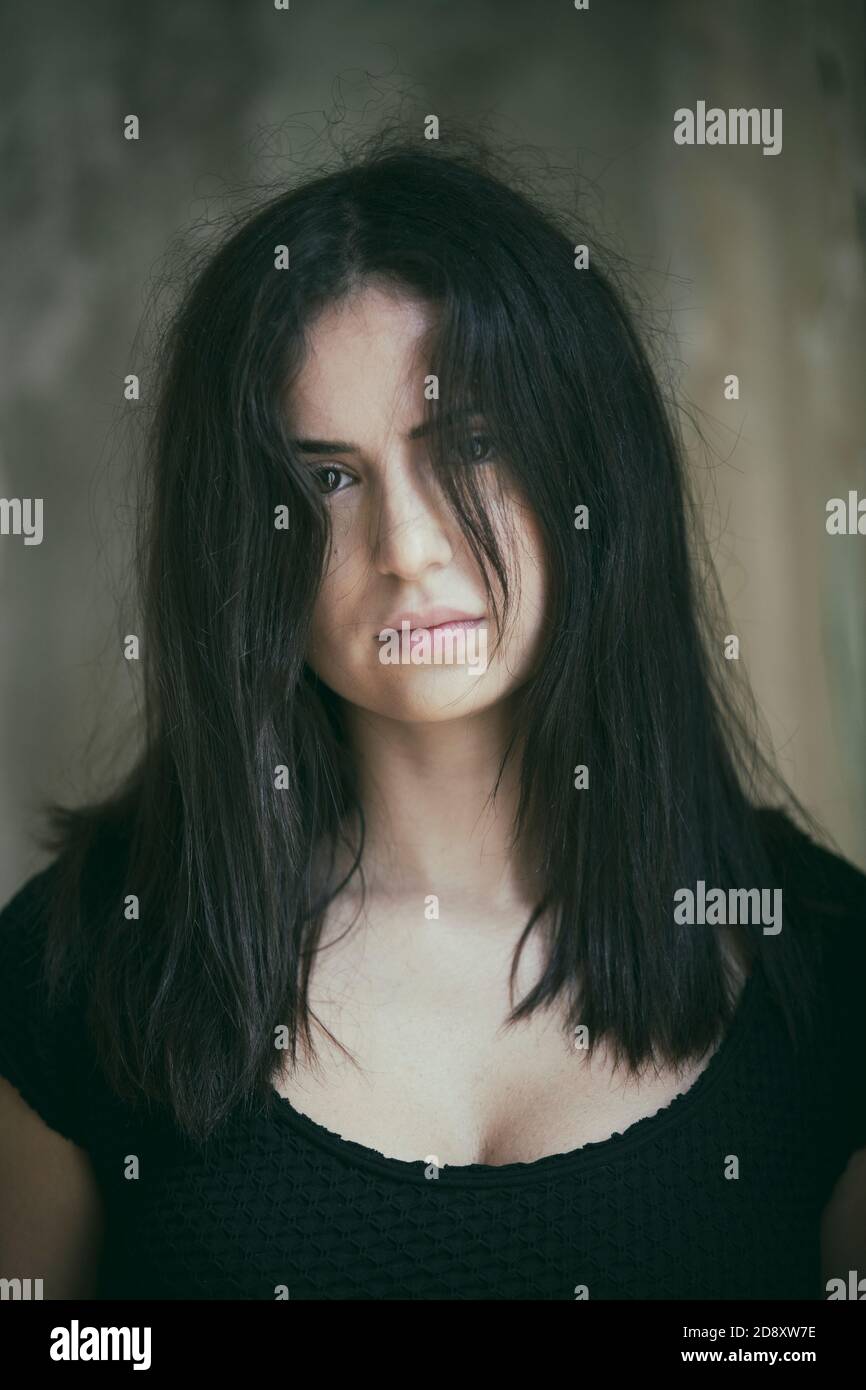 Sad woman with tousled hair looking at camera Stock Photo