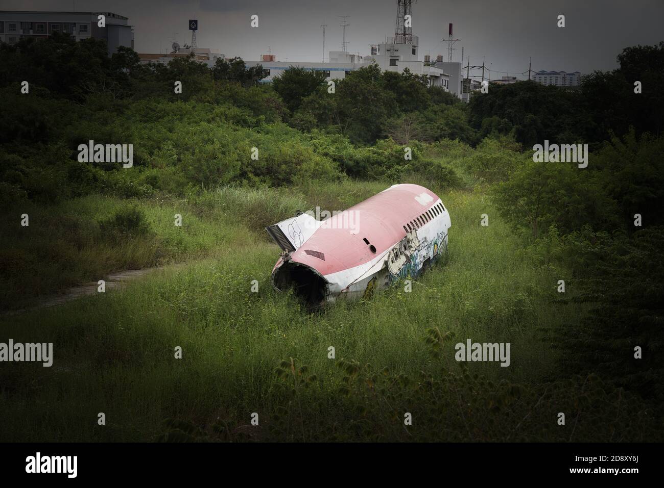 This unique photo shows wreckage of a passenger airplane lying in the middle of a meadow in an airplane cemetery in Bangkok.- Thailand Stock Photo