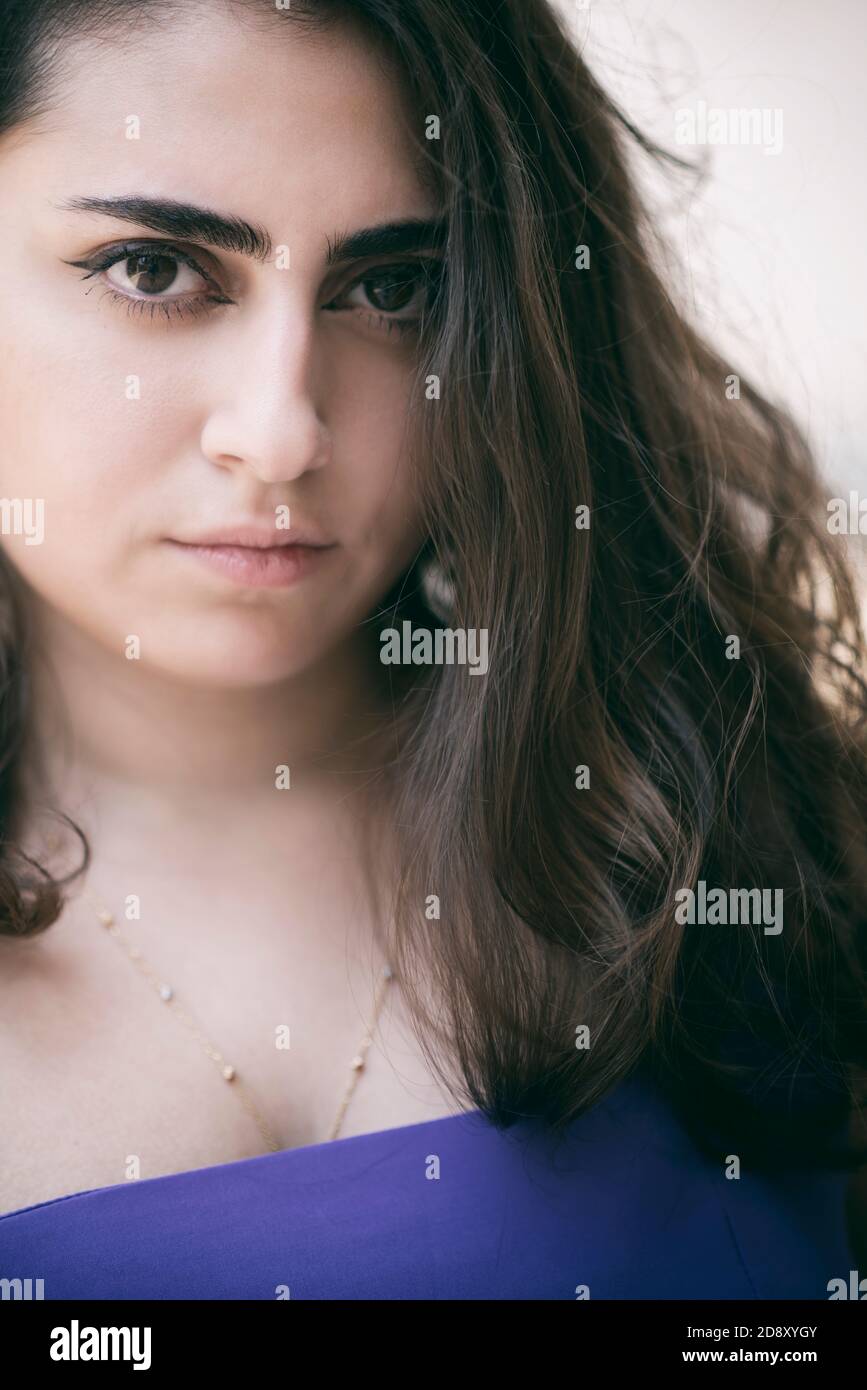 Serious young woman looking at camera outdoors Stock Photo - Alamy