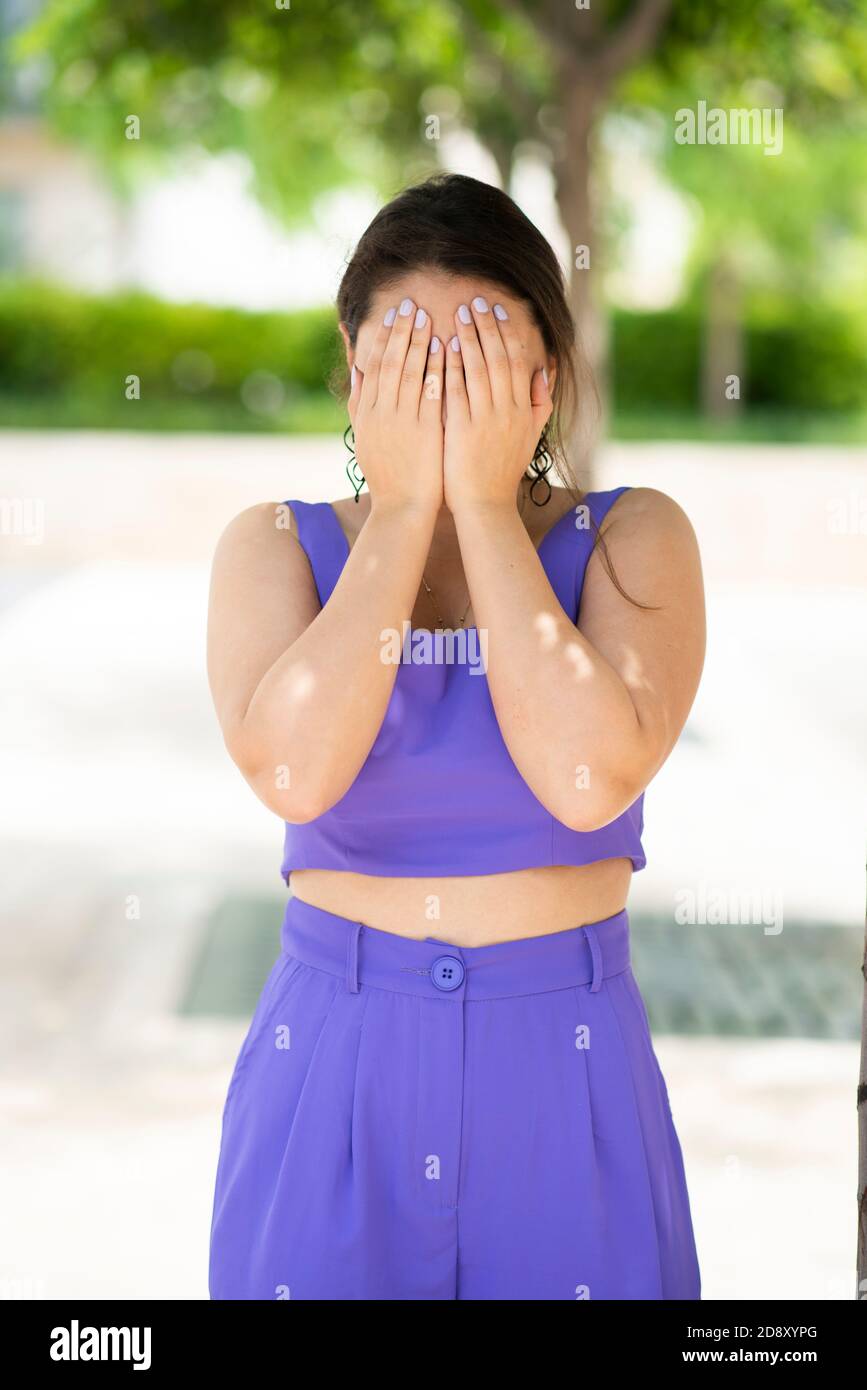 Stressed woman hiding face with hands crying outdoors Stock Photo