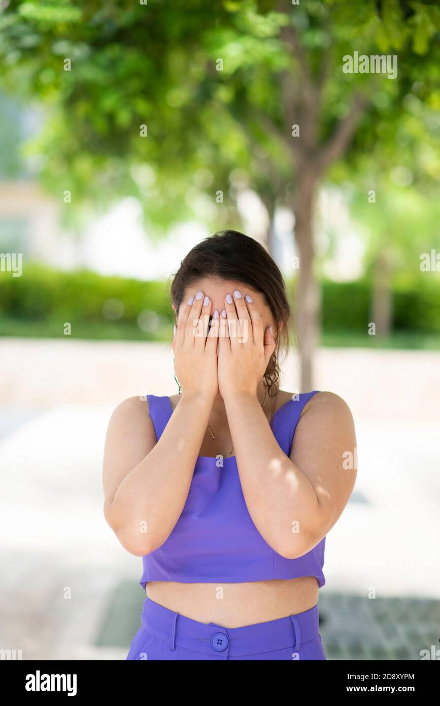 Stressed woman hiding face with hands crying outdoors Stock Photo