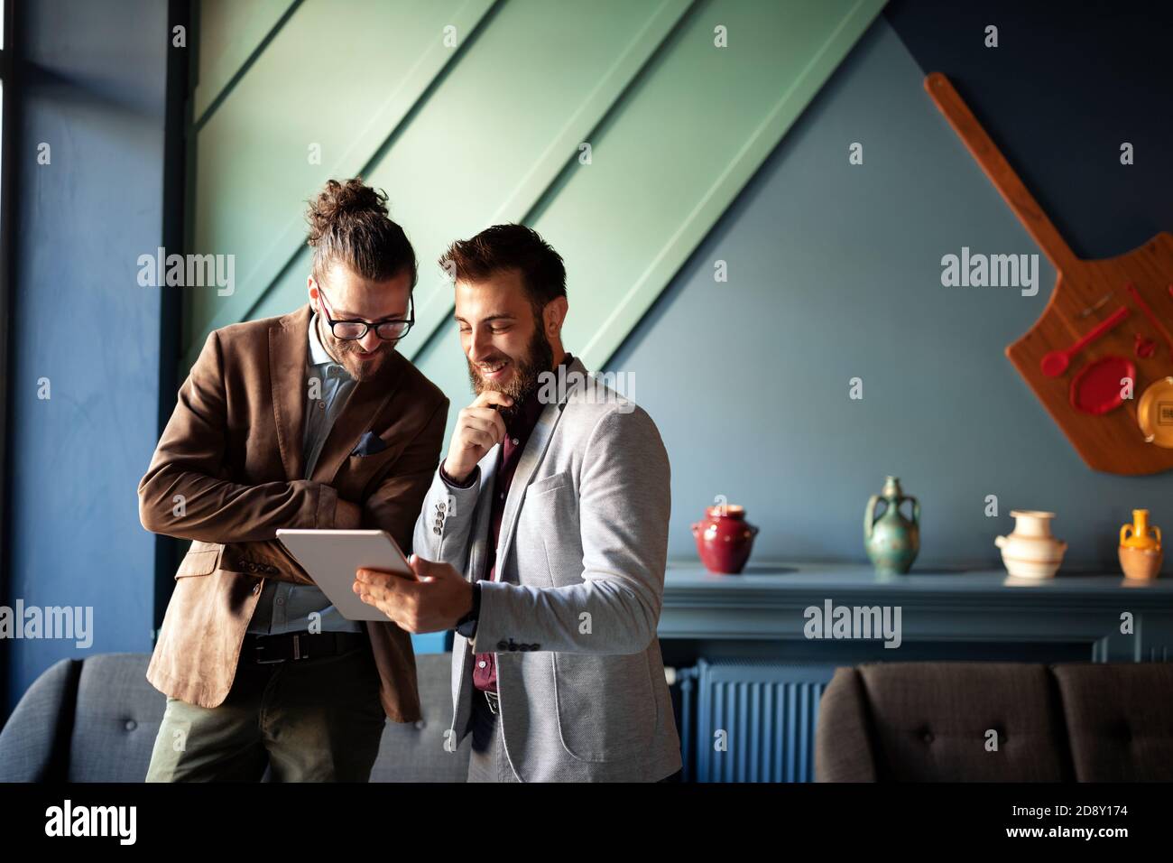 Portrait of happy businessmen using digital devices at meeting Stock Photo