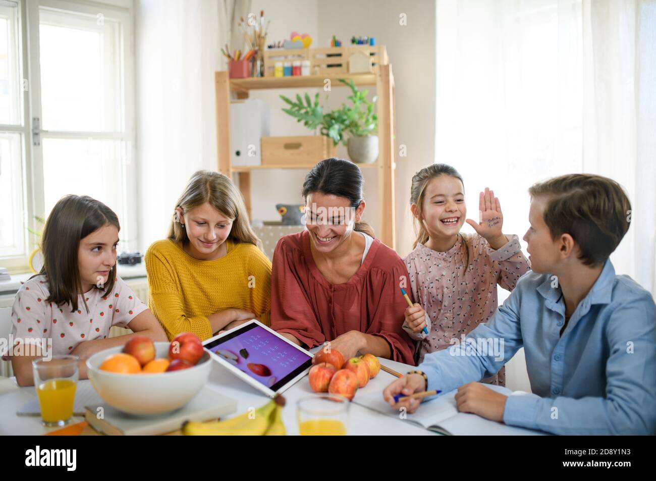 Group of homeschooling children with teacher studying indoors, coronavirus concept. Stock Photo