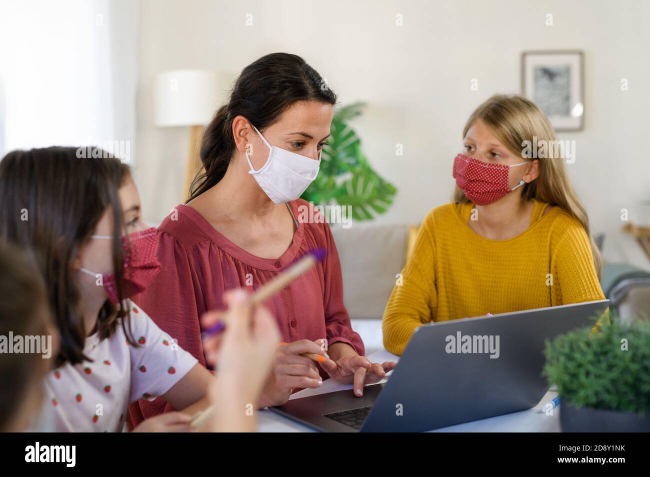 Group of homeschooling children with teacher studying indoors, coronavirus concept. Stock Photo