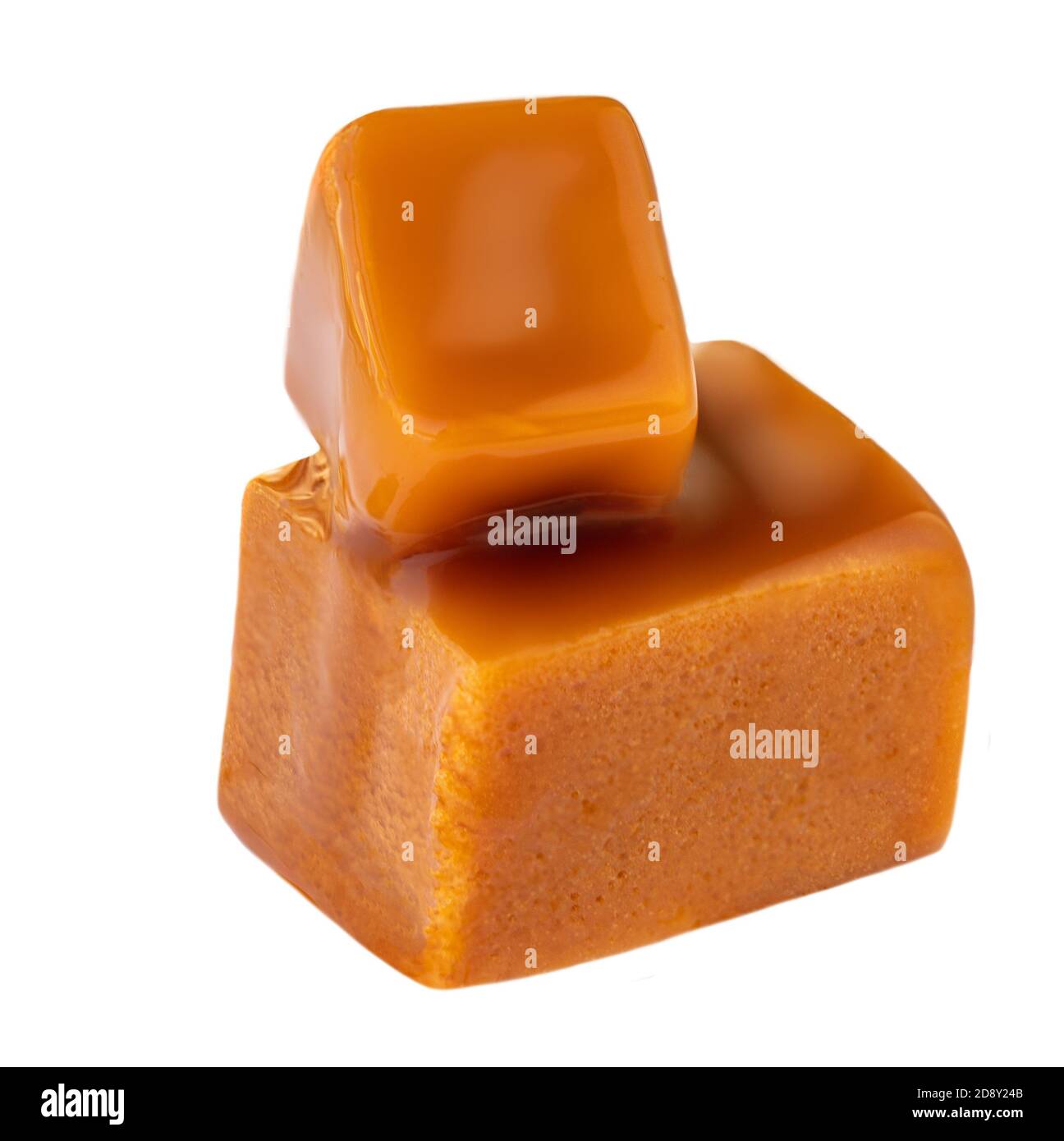 Caramel sauce flowing on caramel candies, isolated on white background