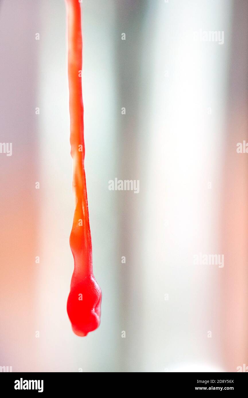 Long drip of red candle wax Stock Photo