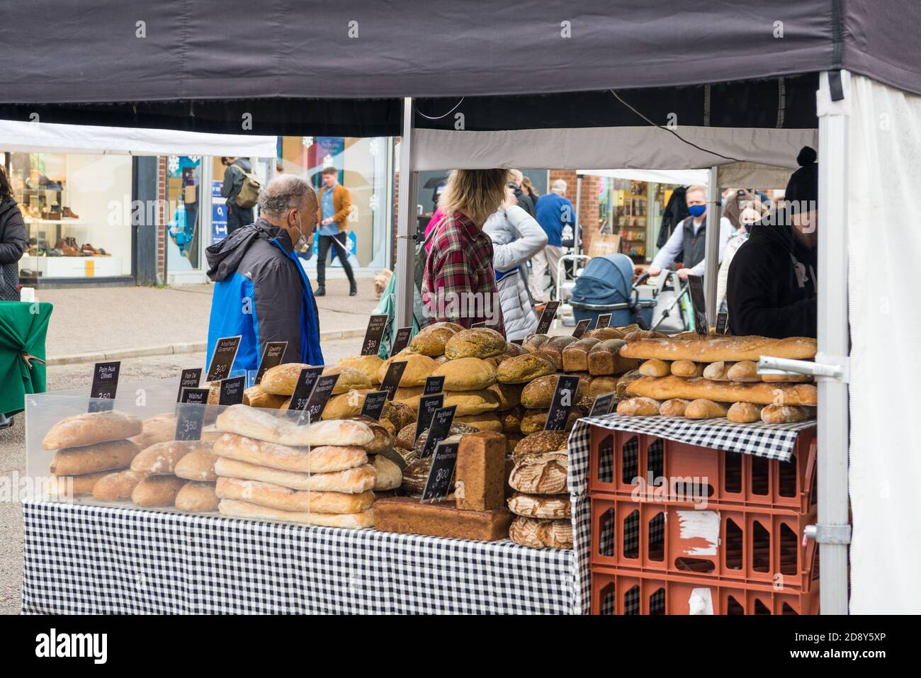 People buying bread from a Saturday market stall in St. Albans city centre, St. Albans, Hertfordshire, England, UK. Stock Photo