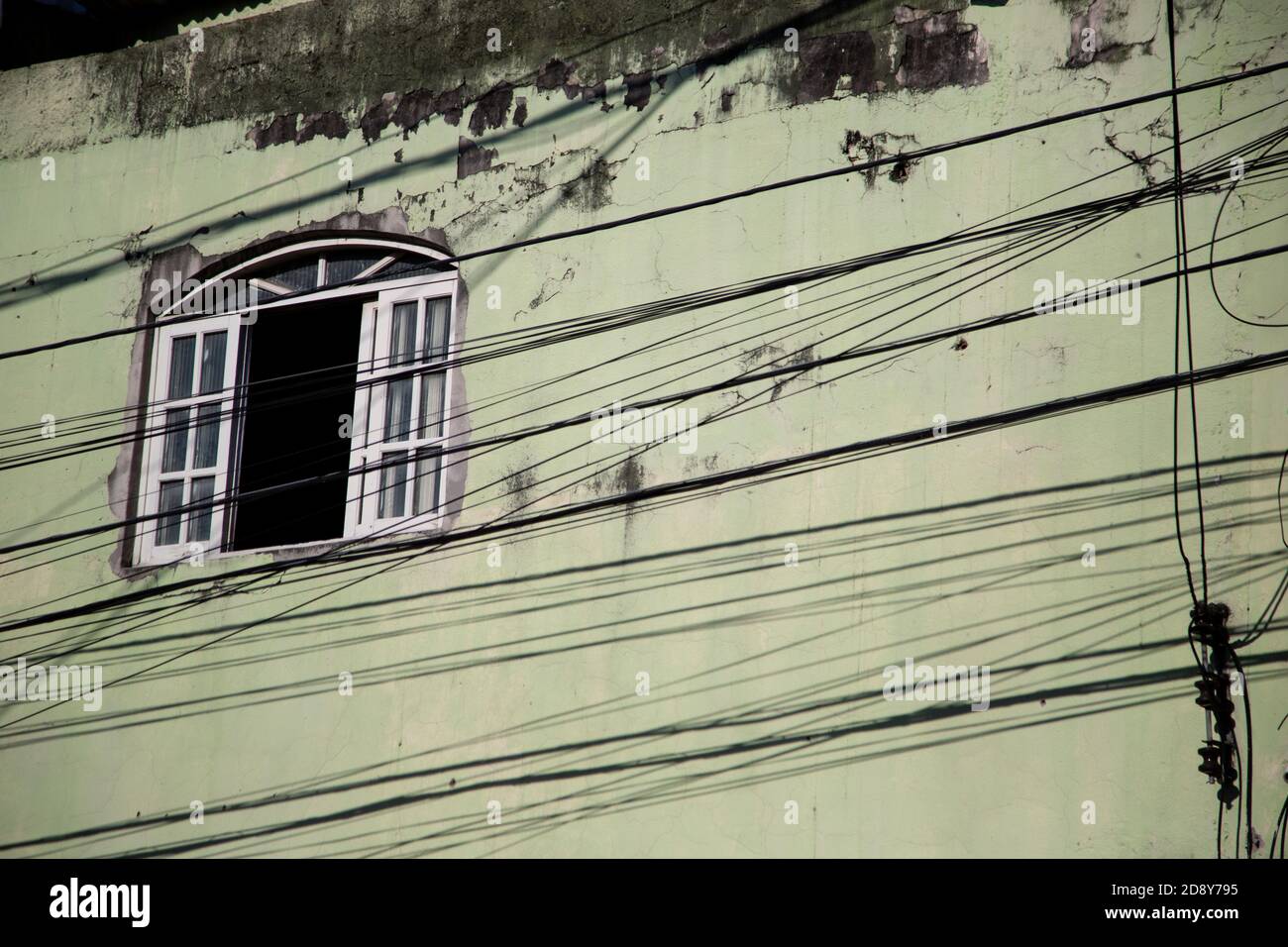 Low angle shot of an old weathered building with electricity wires in ...