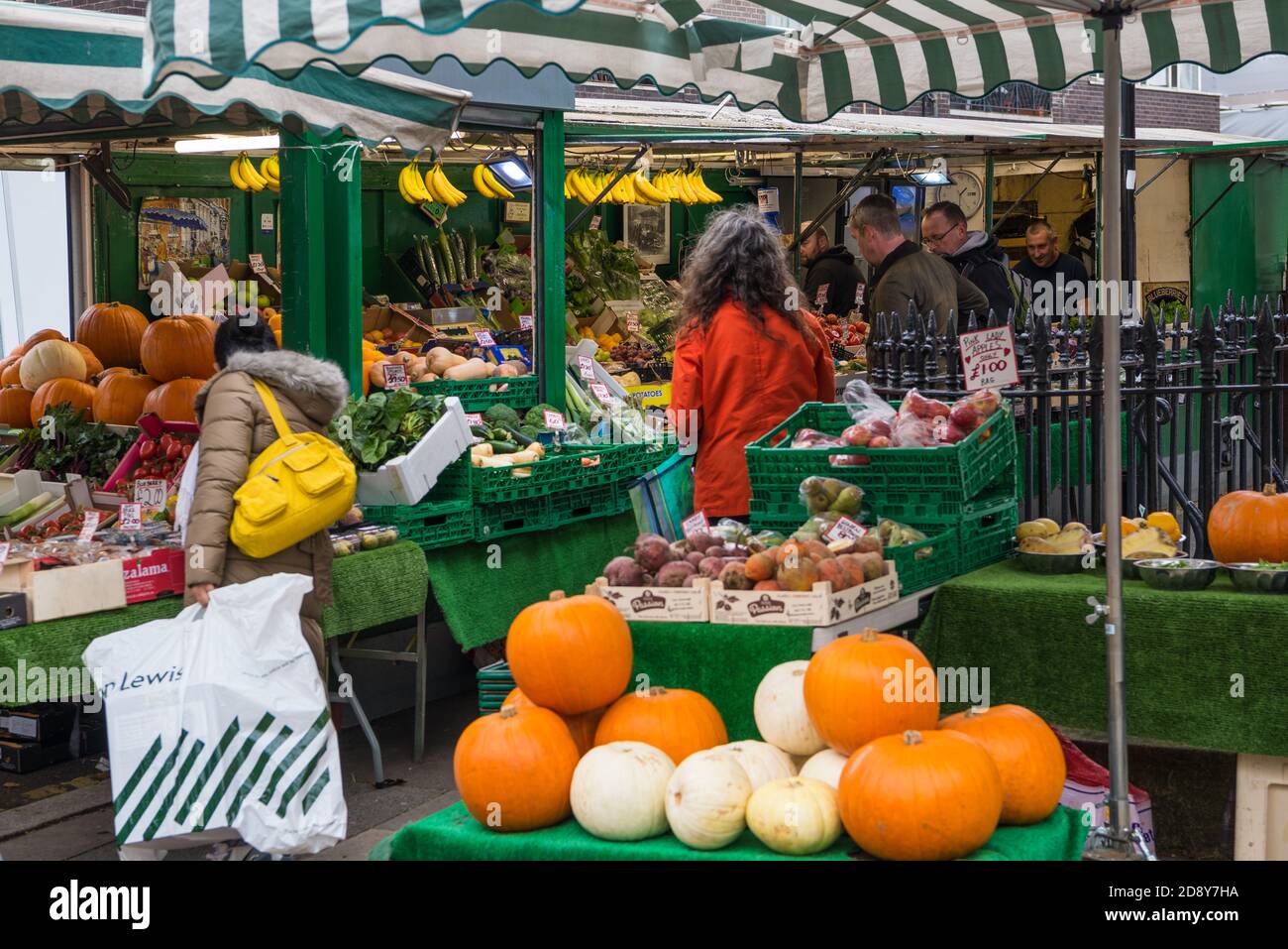 Fruit and vegetables stalls on Chiswick High Road and people out and about shopping on an early autumn Saturday morning. Stock Photo