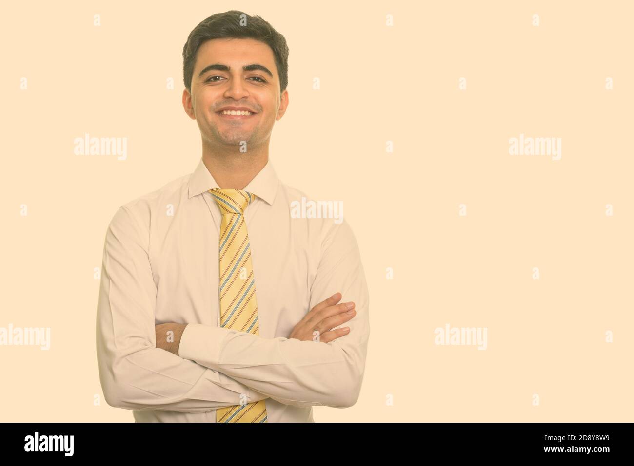 Portrait of happy young handsome Persian businessman smiling with arms ...