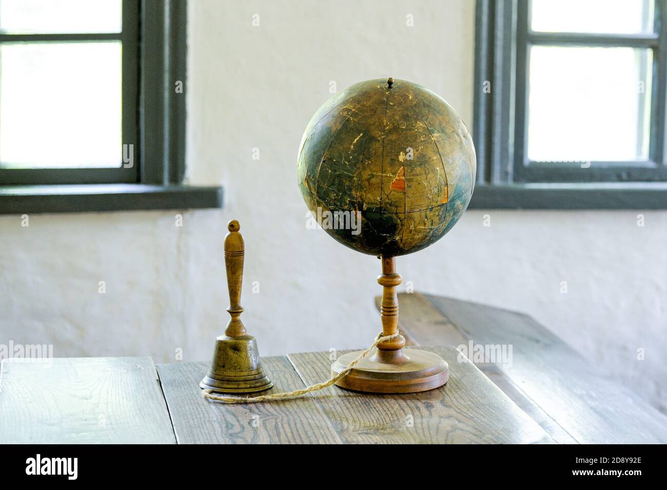An old globe lying on a table against the background class room. Retro ...