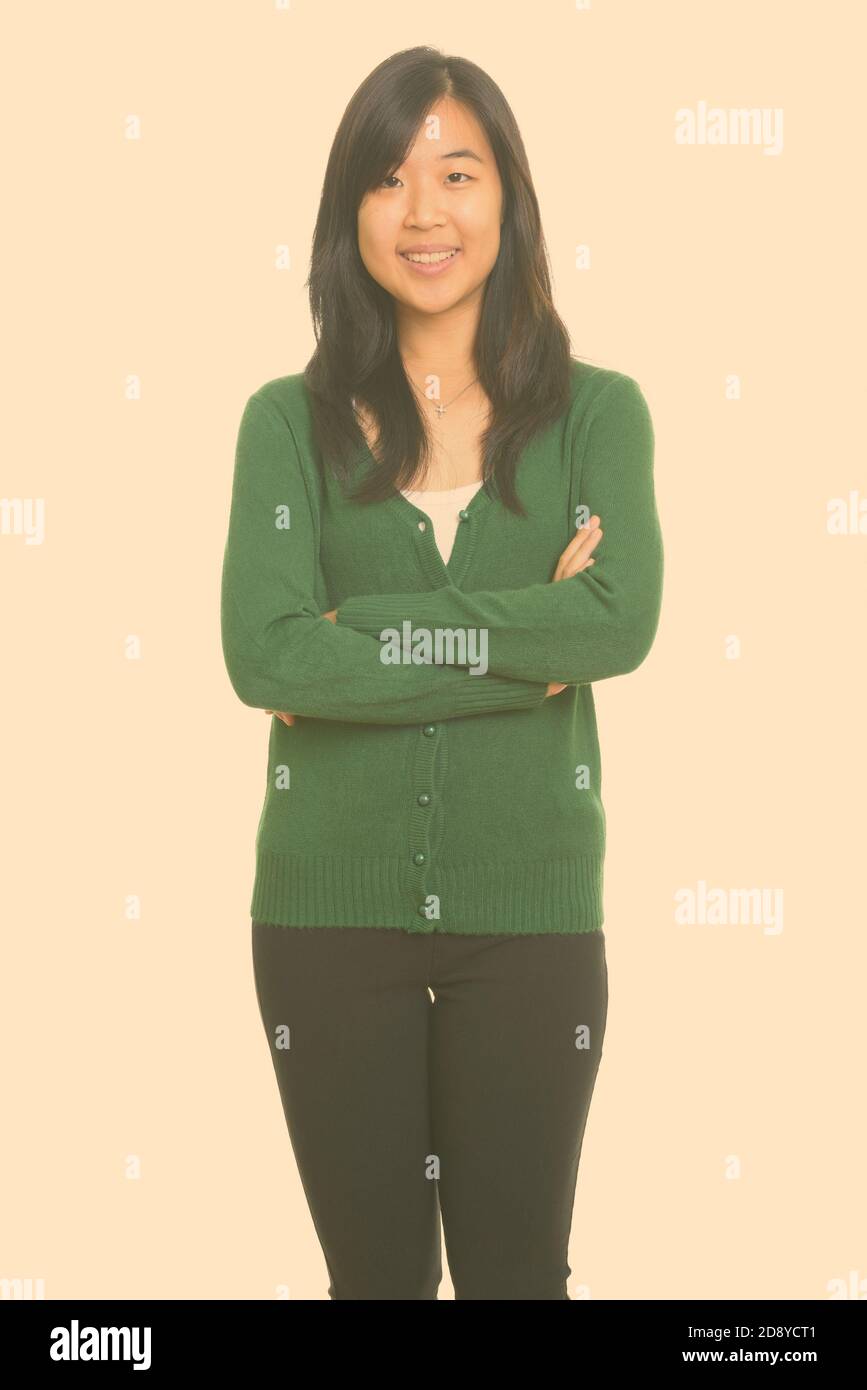 Portrait of happy young beautiful Asian woman smiling with arms crossed ...
