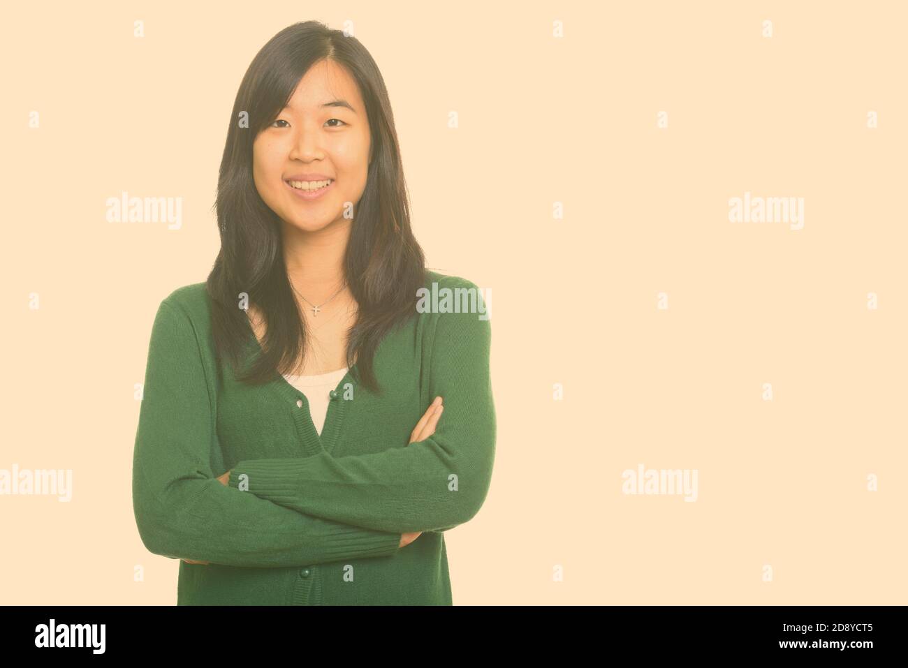 Portrait of happy young beautiful Asian woman smiling with arms crossed ...