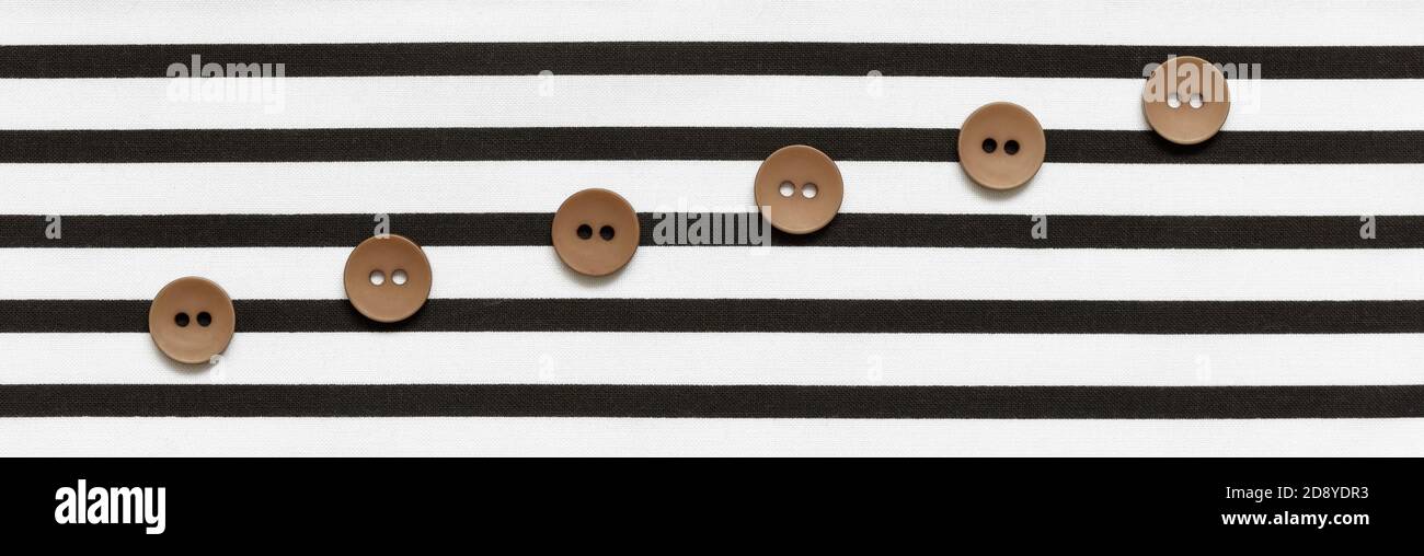 Buttons on the striped fabric in the form of a stave Stock Photo