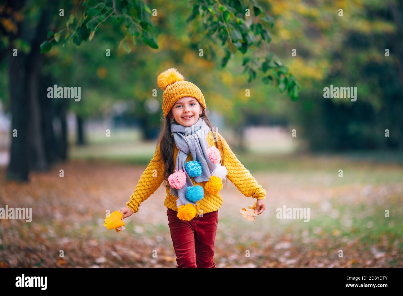 Little smiling girl playing with autumn leaves in a sunshine park Stock ...
