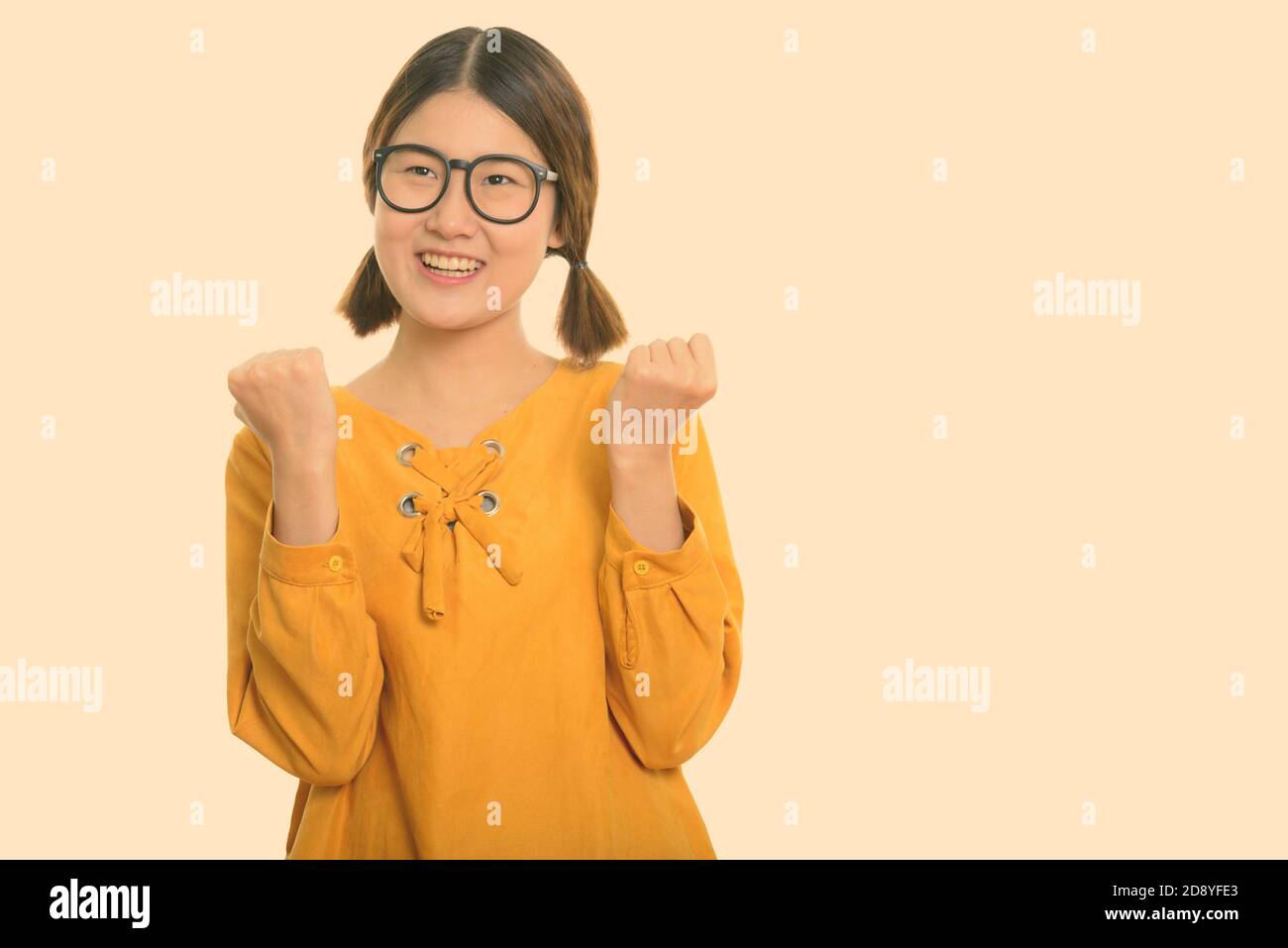 Thoughtful young happy Asian woman smiling while looking excited Stock ...