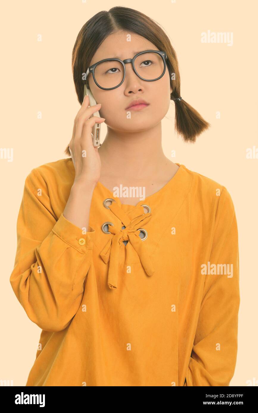 Young bored Asian woman talking on mobile phone Stock Photo