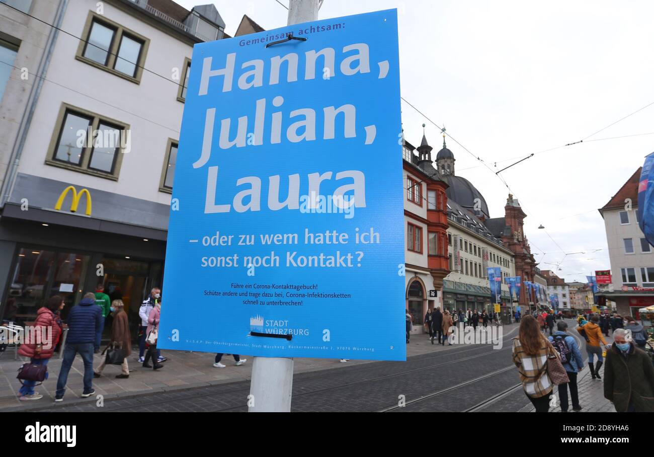 30 October 2020, Bavaria, Würzburg: A poster in the city centre reads 'Attentive together: Hanna, Julian, Laura - or who else did I have contact with? The city of Würzburg recommends keeping a contact diary and has put up posters at around 200 locations for this purpose. Photo: Karl-Josef Hildenbrand/dpa Stock Photo