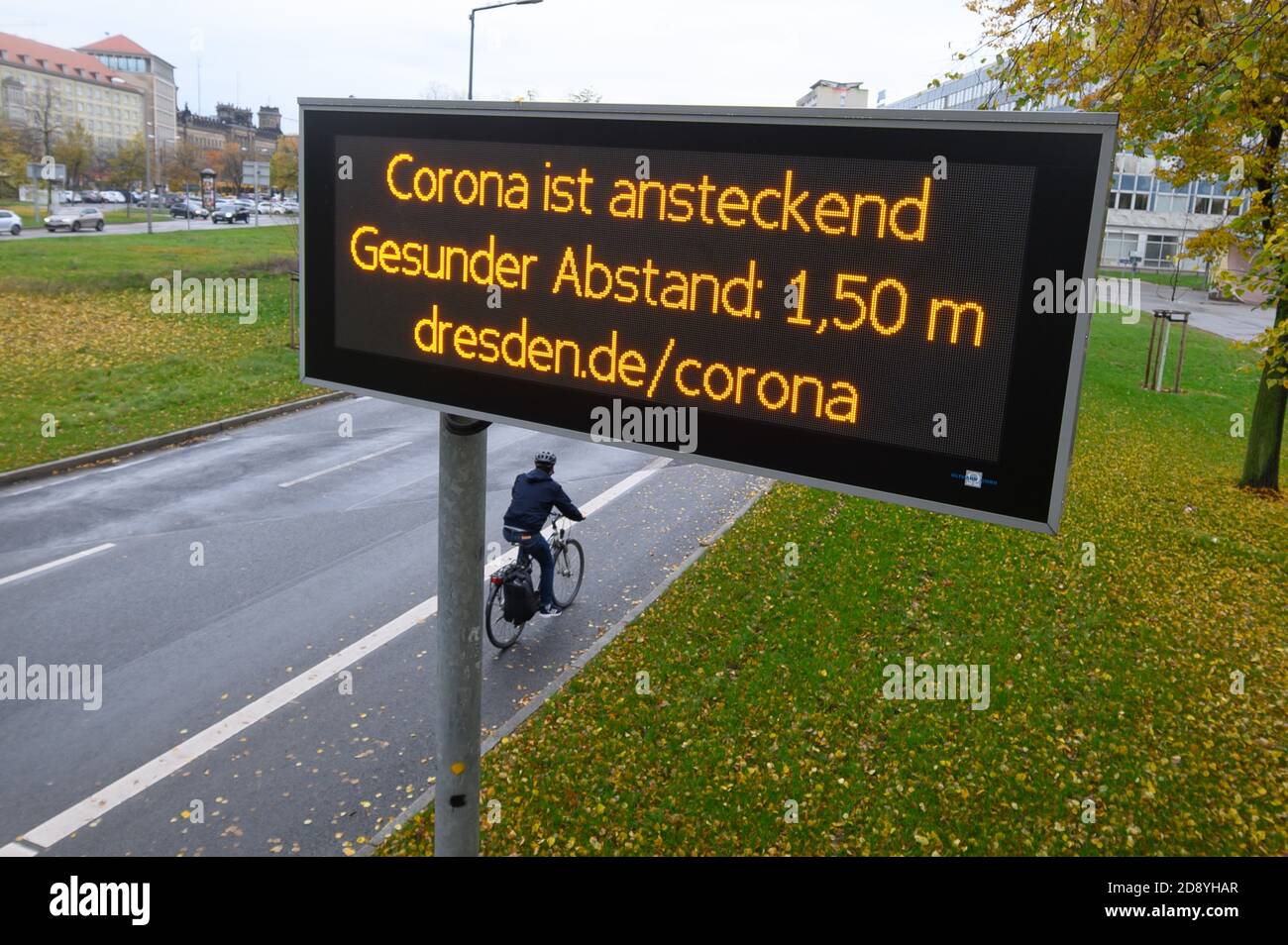Dresden, Germany. 02nd Nov, 2020. A digital display board in downtown Dresden reads 'Corona is contagious Healthy distance: 1.50m'. The federal and state governments have decided on a partial lockdown starting on the same day. Among other things, restaurants, leisure facilities and cultural institutions will have to close. Credit: Sebastian Kahnert/dpa-Zentralbild/dpa/Alamy Live News Stock Photo