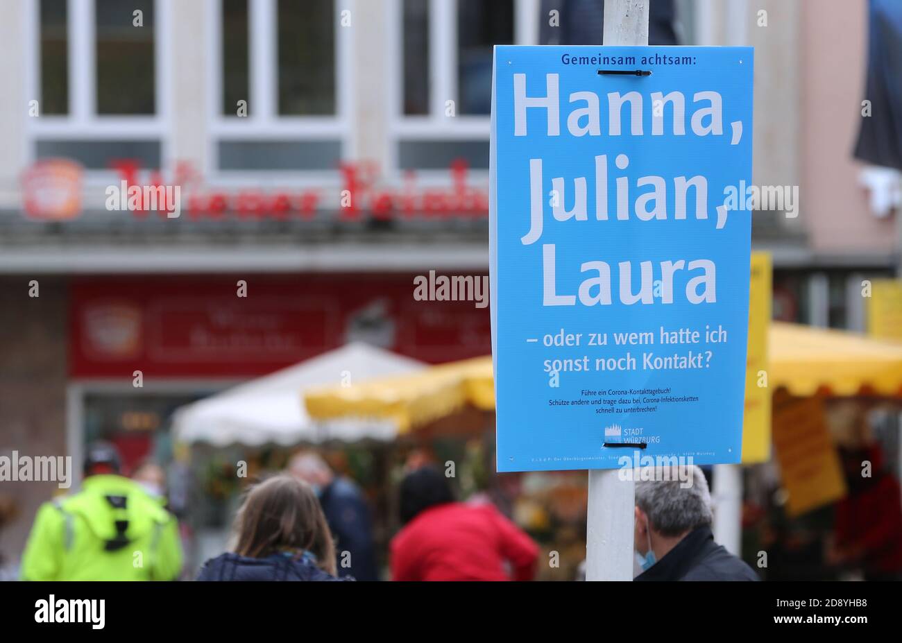 30 October 2020, Bavaria, Würzburg: On a blue poster in the city centre you can read 'Attentive together: Hanna, Julian, Laura - or who else did I have contact with? The city of Würzburg recommends keeping a contact diary and has put up posters at around 200 locations for this purpose. Photo: Karl-Josef Hildenbrand/dpa Stock Photo