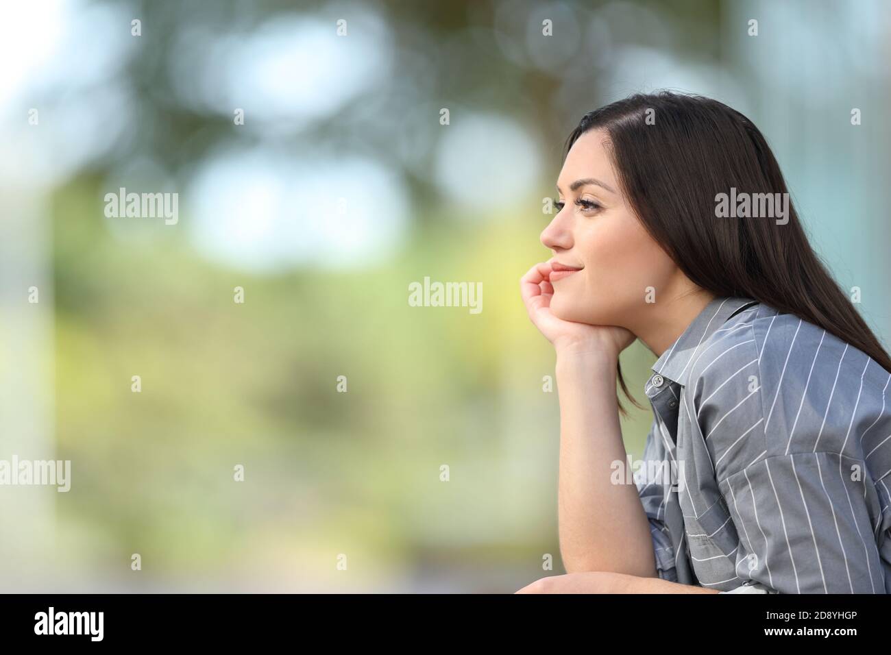 Side view portrait of a relaxed woman meditating looking away in the street Stock Photo