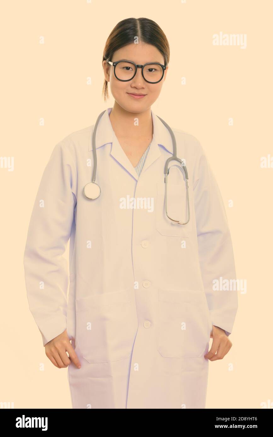 Studio shot of young beautiful Asian woman doctor standing Stock Photo ...