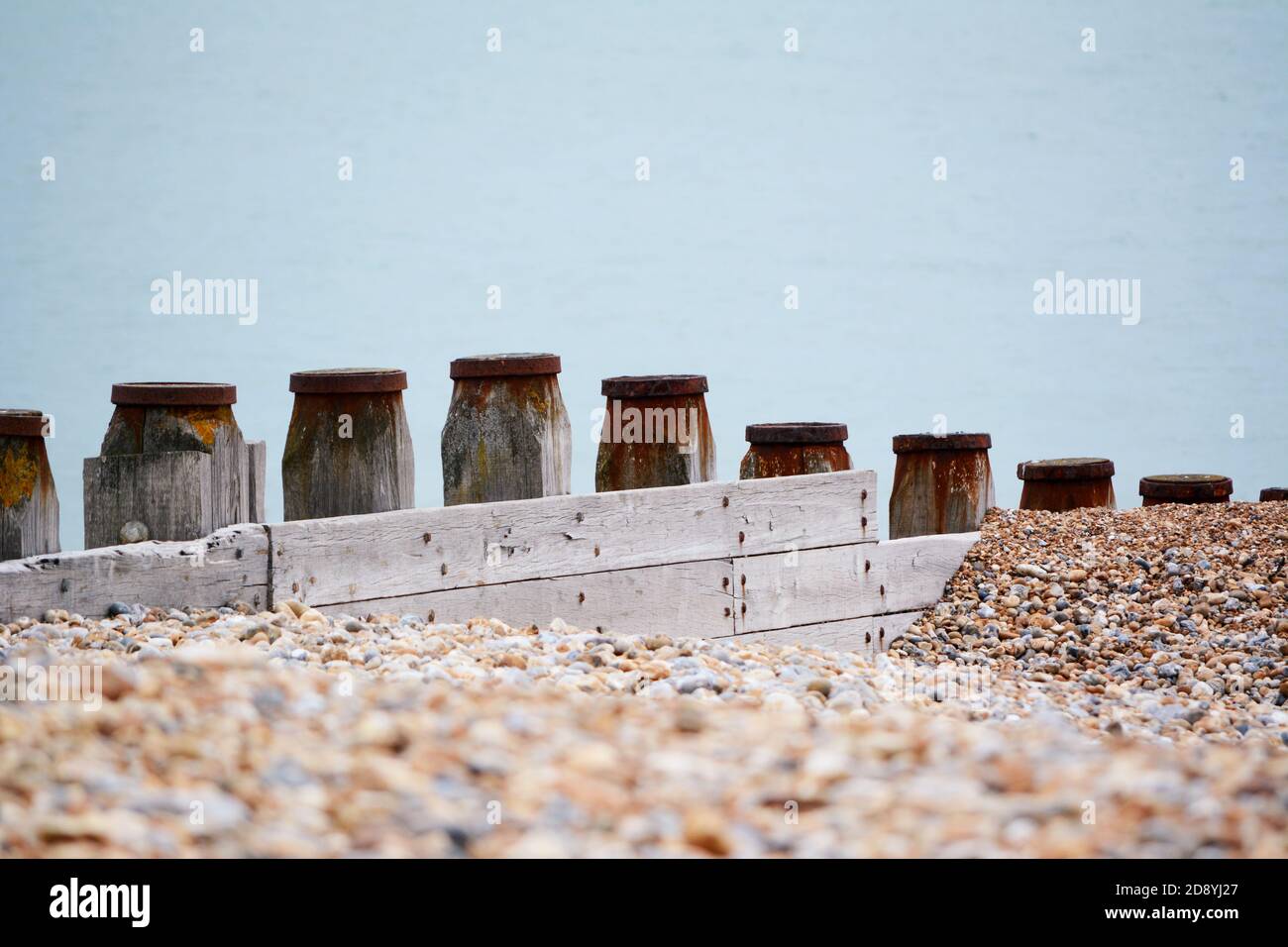 Wooden groynes form sea defences to prevent coastal erosion on shingle beach in Eastbourne, East Sussex Stock Photo