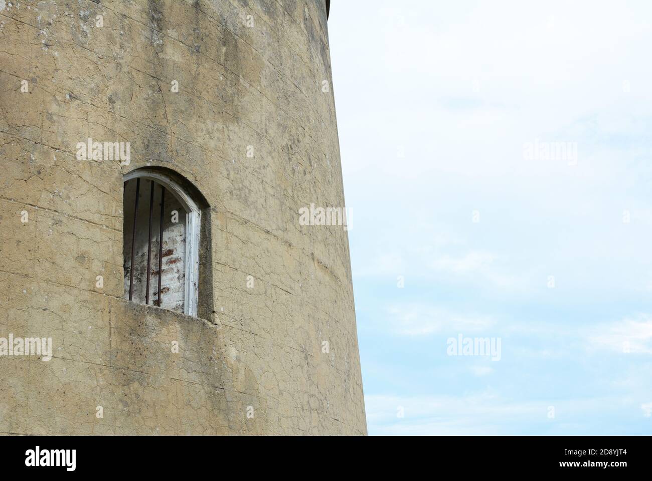 Window with metal bars set into the thick wall of the Martello tower known as Wish Tower in the coastal town of Eastbourne, East Sussex Stock Photo