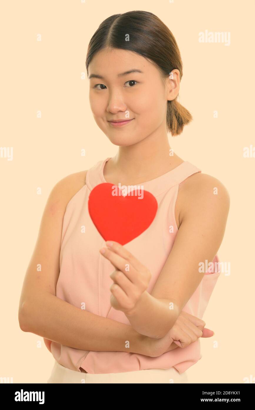Studio shot of young beautiful Asian woman holding red heart Stock ...