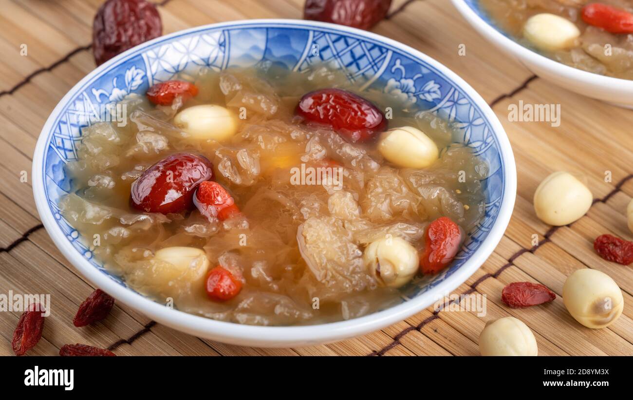 Close up of traditional Chinese sweet snow white fungus soup with lotus seed, red dates (jujube) and wolfberry (goji berry, gojiberry) on white backgr Stock Photo