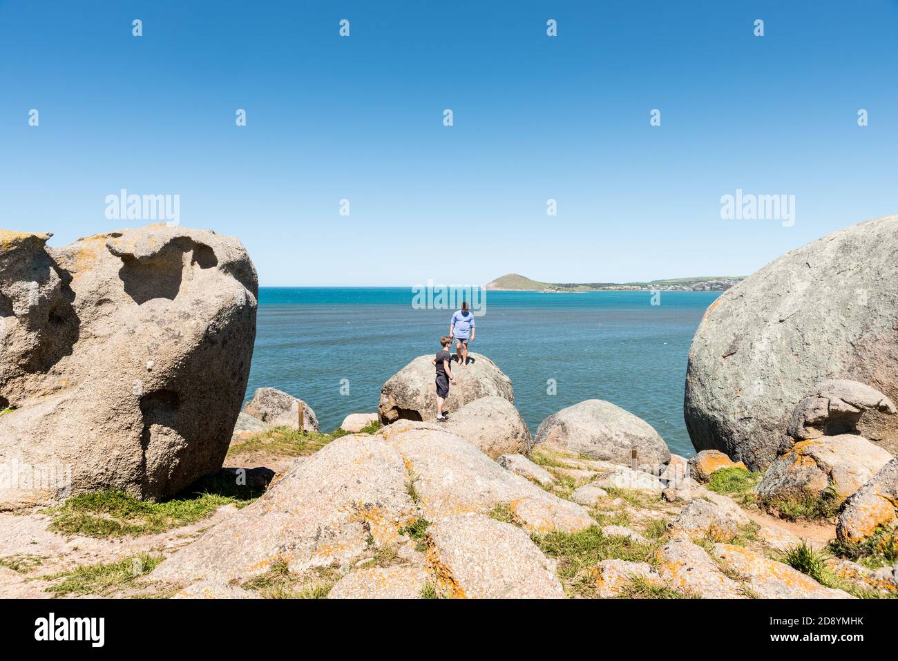 Tourists explore the large granite boulders on Granite Island off Victor Harbor, South Australia Stock Photo