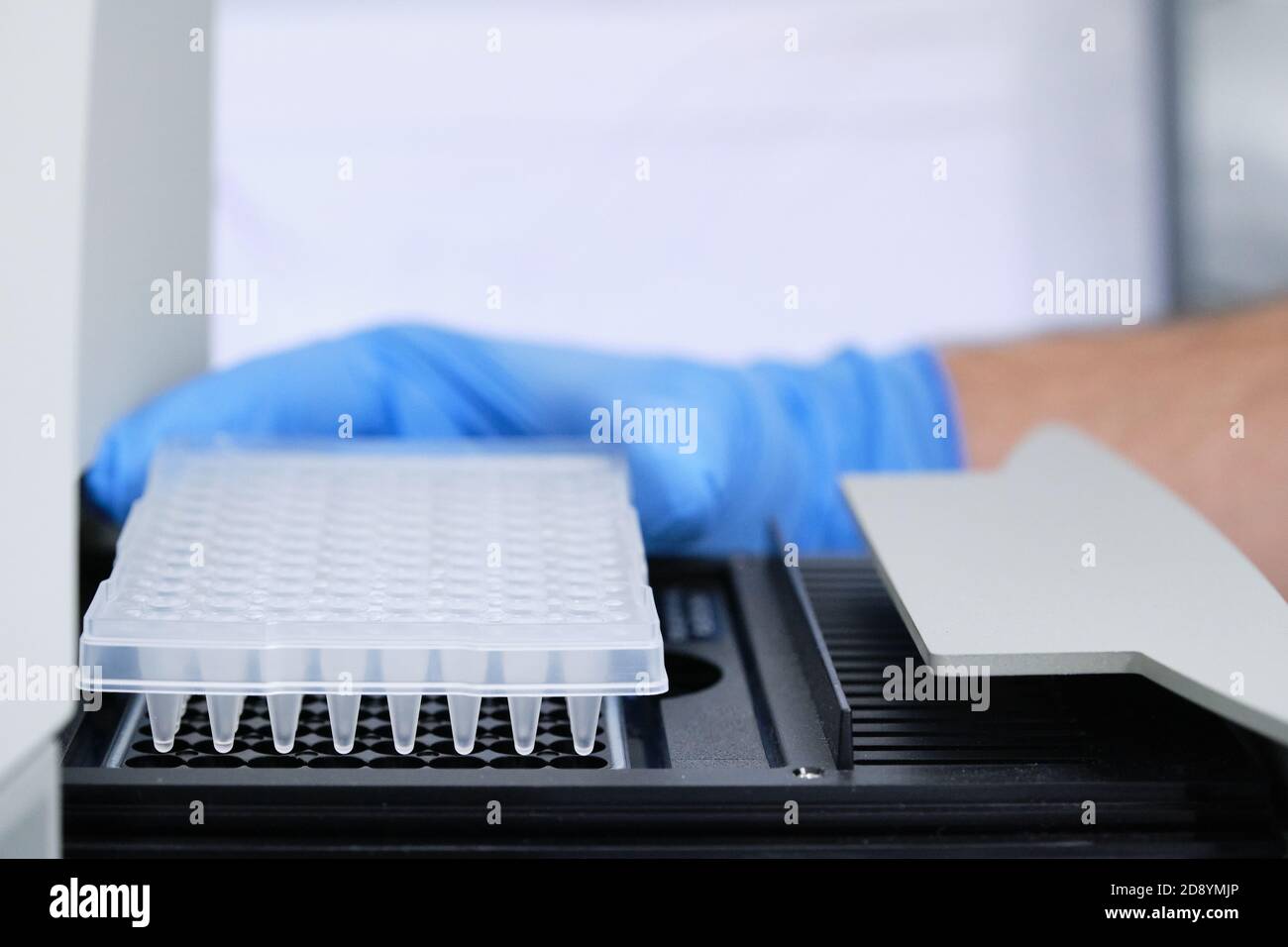 A researcher putting PCR plate on the thermal cycler for DNA