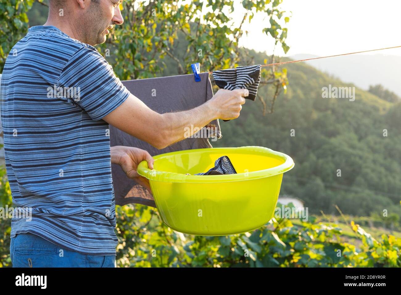Man hanging out clothes to dry. Concept of housework. Stock Photo