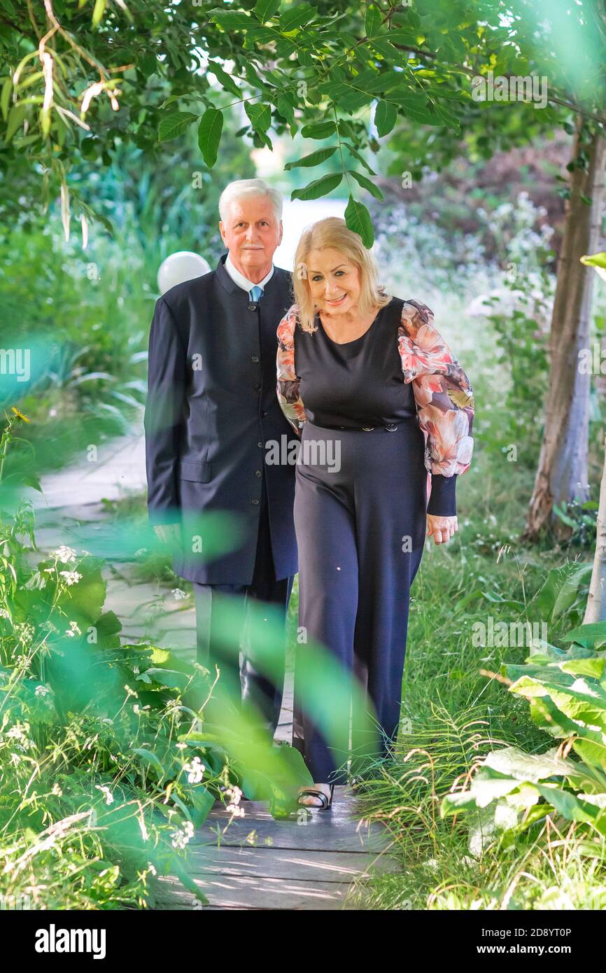 Beautiful elegant senior couple walking in the park having nice time together Stock Photo