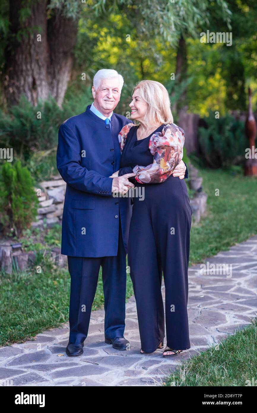 Beautiful elegant senior couple walking in the park having nice time together Stock Photo