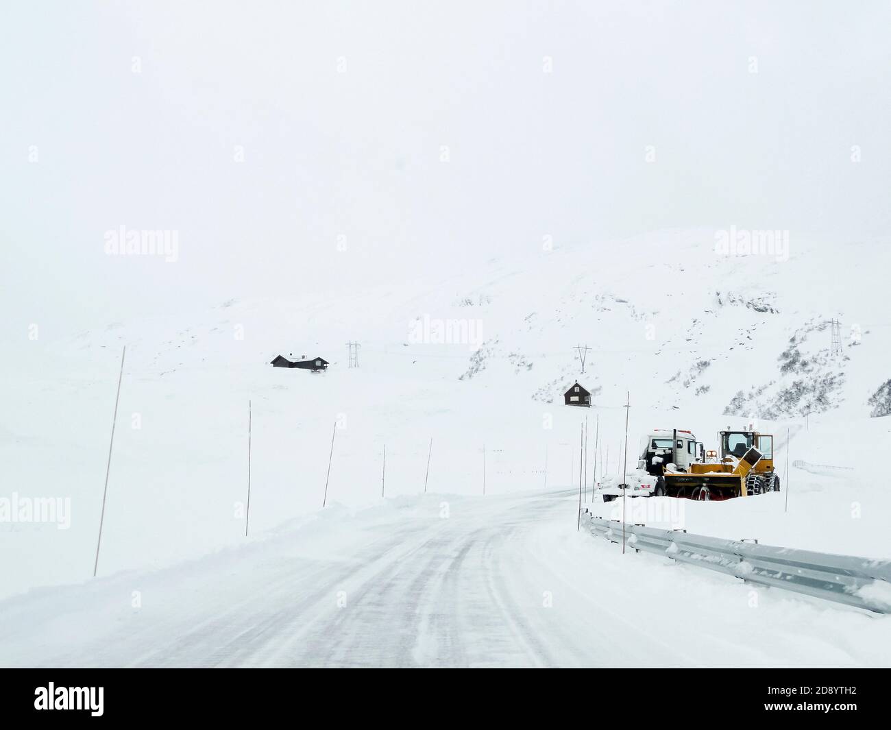 Excavator and snow shovel truck on snowy road at work in Norway Stock