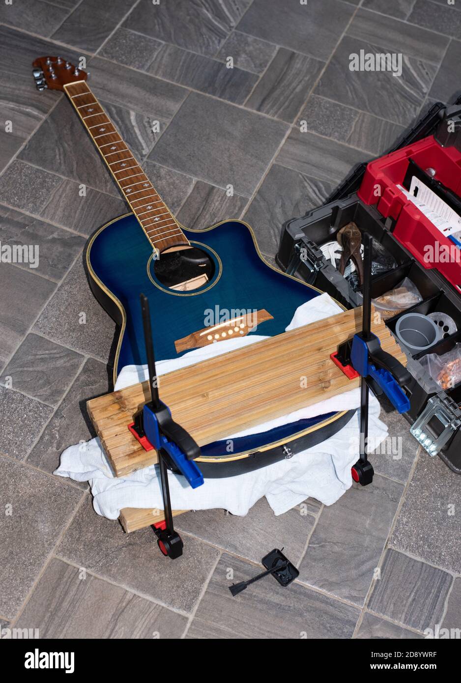 A smashed and broken guitar being restored, glued and clamped number 3958 Stock Photo