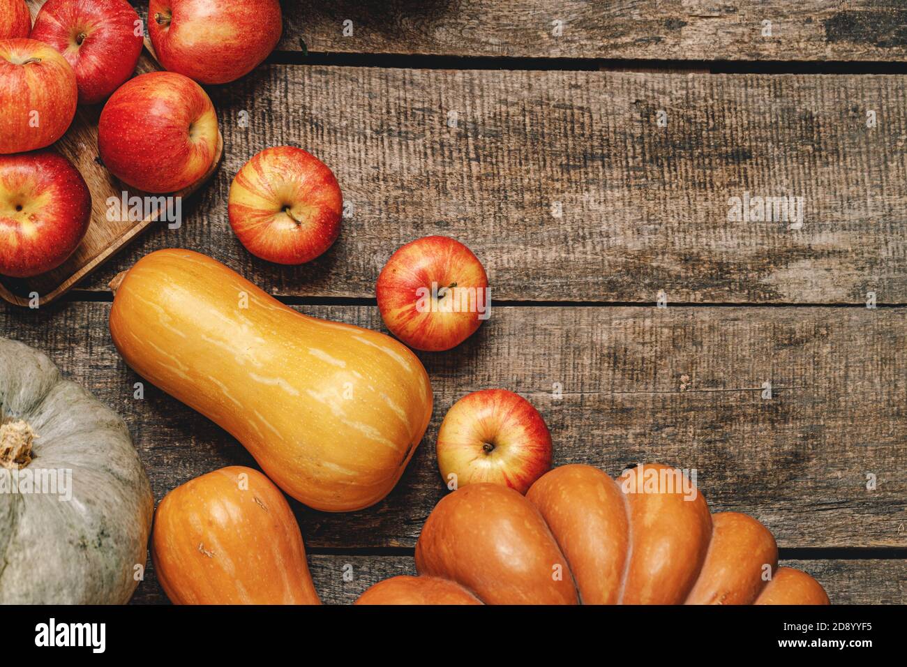 Autumn harvest of pumpkins and apples on wooden board Stock Photo - Alamy