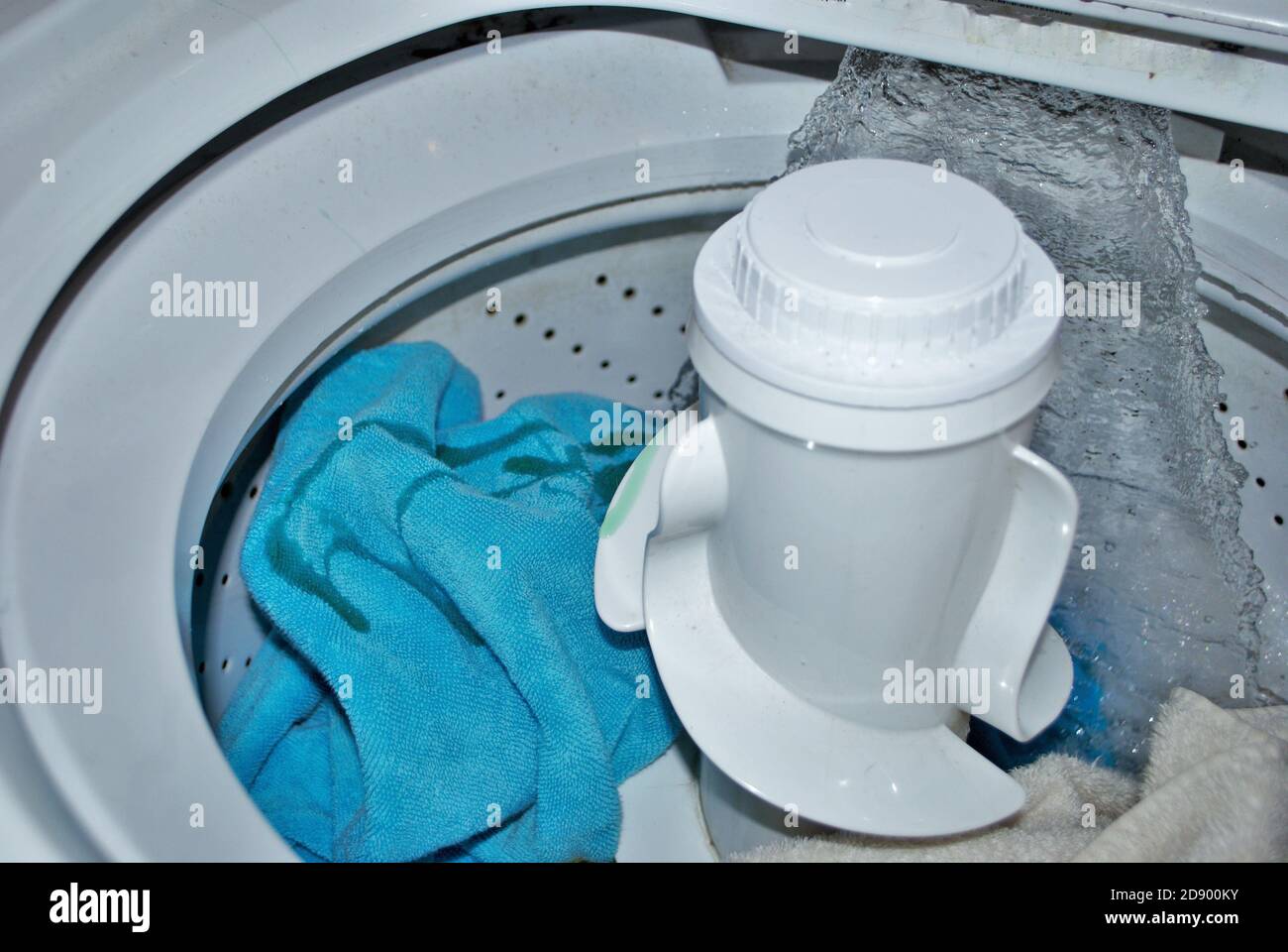 load of dirty towels in a washing machine filling with water Stock