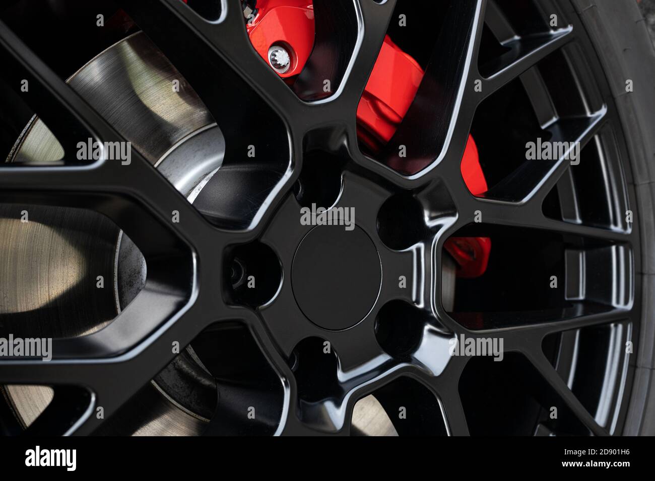 Black Wheel rim and red brake caliper of a sport car. Close up Stock Photo