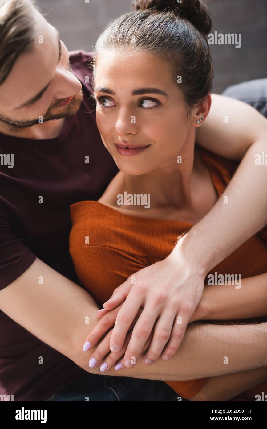 young woman looking at tender boyfriend hugging her from back Stock ...