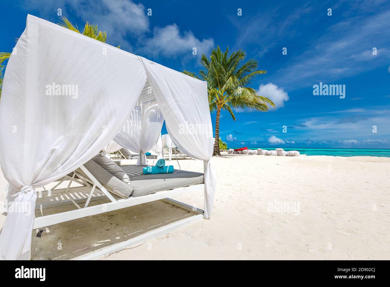 Amazing tropical beach scene with white canopy and curtain for luxury summer relaxation concept. Blue sky with white sand for sunny beach landscape Stock Photo