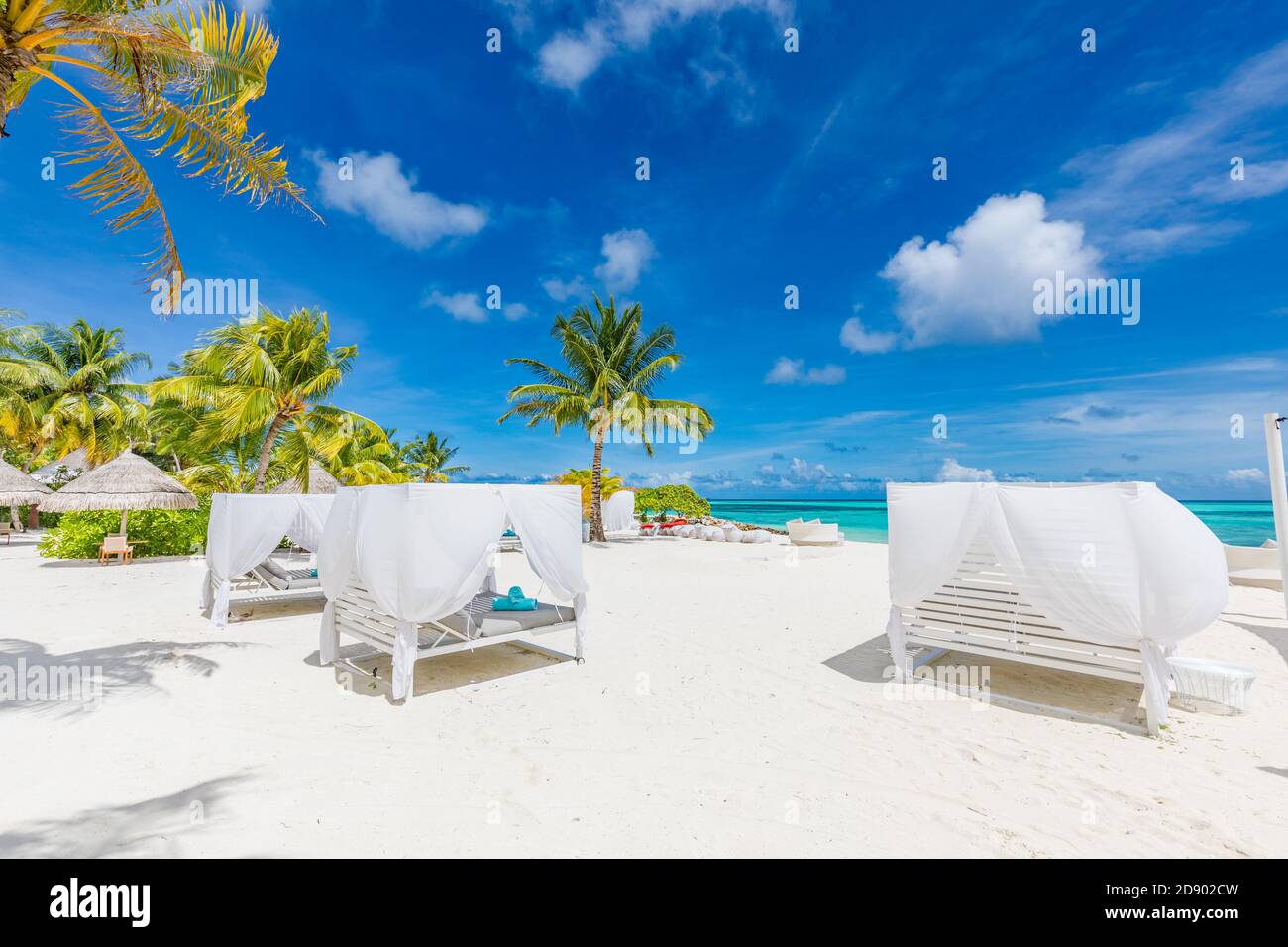 Amazing tropical beach scene with white canopy and curtain for luxury summer relaxation concept. Blue sky with white sand for sunny beach landscape Stock Photo