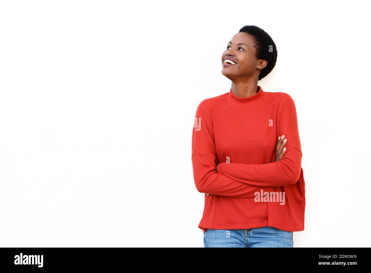 Portrait of smiling young african woman with arms crossed against ...