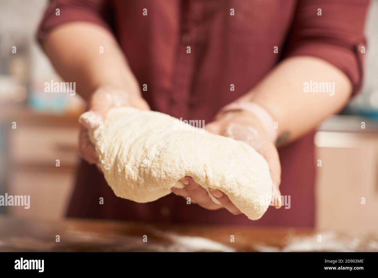 Female hands holding the finished raw dough close up Stock Photo