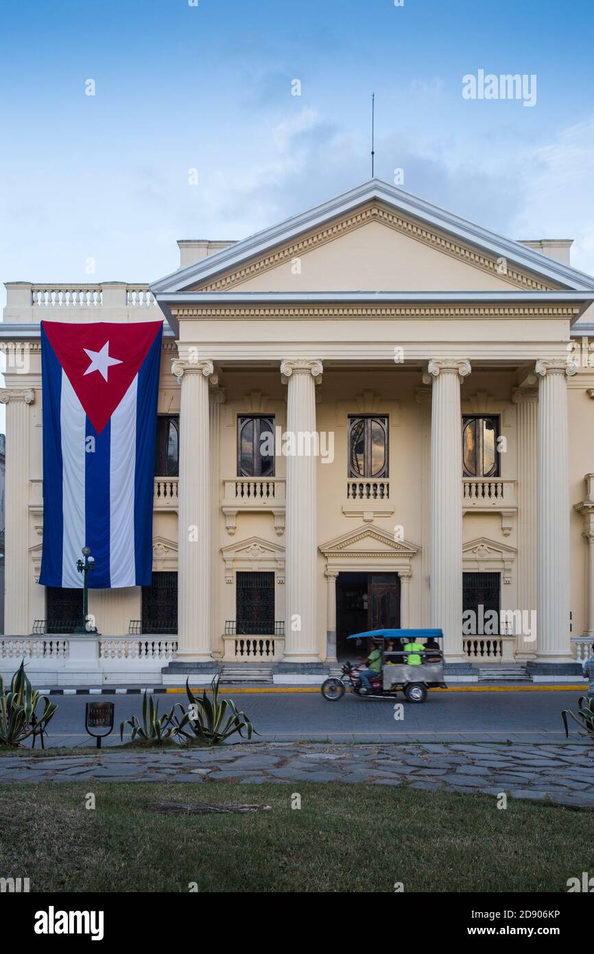 Cuba, Santa Clara, Parque Vidal, Cuban flag hanging from Provincial Palace - Palacio Provincial (home to Jose Marti Provincial Library), after the dea Stock Photo