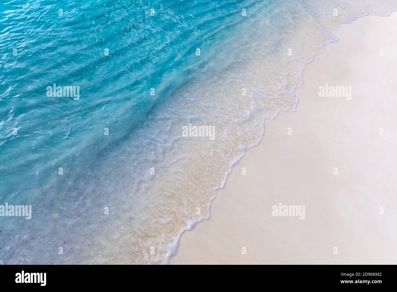 Soft wave of blue ocean on sandy beach. Relaxing ocean coast background. Soft gentle waves splashing on white sand, tropical beach shore coastline Stock Photo